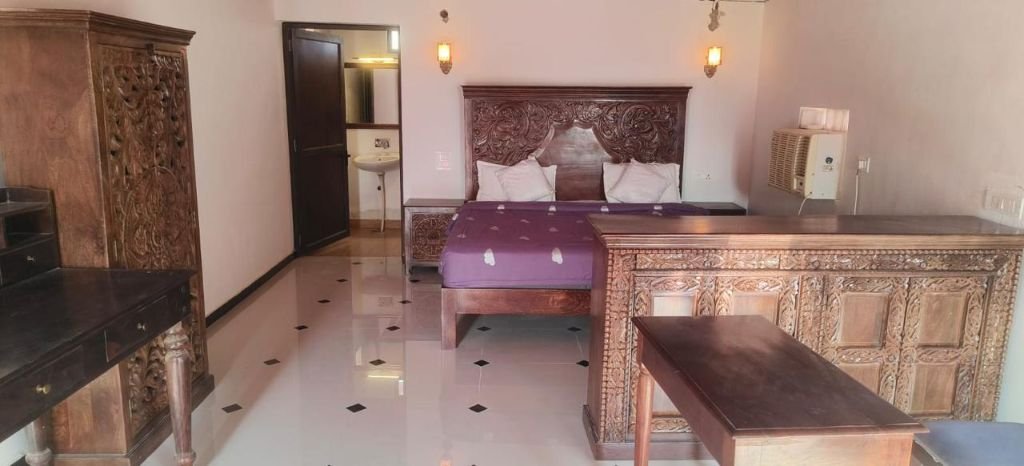 Carved wooden furniture in luxury tent bedroom